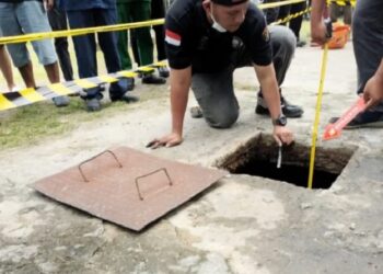 Petugas Polres Labuhanbatu Selatan dan Polsek Kotapinang melakukan olah TKP di septic tank yang merenggut nyawa balita 3 tahun. (FOTO: iNews/RANDI KURNIAWAN)