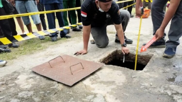 Petugas Polres Labuhanbatu Selatan dan Polsek Kotapinang melakukan olah TKP di septic tank yang merenggut nyawa balita 3 tahun. (FOTO: iNews/RANDI KURNIAWAN)