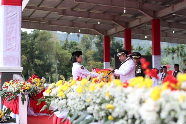 Bupati Pakpak Bharat, Franc Bernhard Tumanggor menyerahkan bendera merah putih untuk dikibarkan Paskibraka.