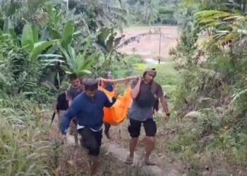 Polisi bersama warga mengevakuasi korban tewas pertikaian di kebun Desa Lahemboho, Kecamatan Alasa, Kabupaten Nias Utara, Sumatera Utara. (foto: iNews/Iman Jaya Lase)