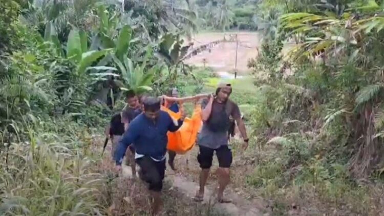 Polisi bersama warga mengevakuasi korban tewas pertikaian di kebun Desa Lahemboho, Kecamatan Alasa, Kabupaten Nias Utara, Sumatera Utara. (foto: iNews/Iman Jaya Lase)