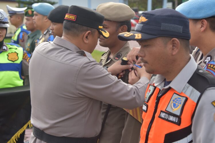 Kapolres Humbang Hasundutan, AKBP Hary Ardianto SH SIK MH, menyematkan pita kepada salah seorang personil tanda dimulainya Operasi “Zebra Toba 2023”,  Senin (4/9/2023), di Lapangan Mapolres, Jl Siborong - borong - Doloksanggul Km 12.