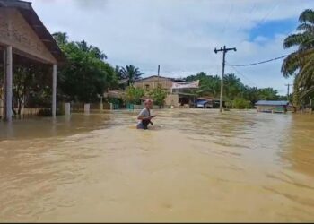 Warga melintasi banjir di Dusun I Desa Piasa Ulu Kecamatan Tinggi Raja Kabupaten Asahan. (Istimewa)