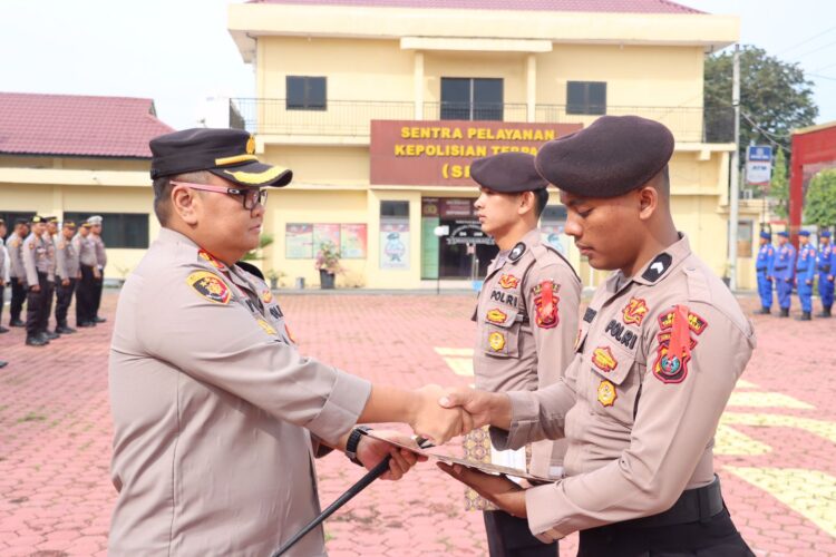 Kapolres Tanjungbalai, AKBP. Ahmad Yusuf Afandi, memberikan penghargaan kepada dua personil Bintara muda, di Lapangan Presisi Polres Tanjungbalai, Selasa (07/11/2023), pukul 09.00 WIB.