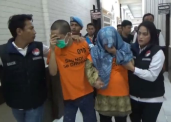 Seorang wanita yang merupakan pejabat Lapas Tanjungpinang, dan anaknya ditangkap Satreskoba Polresta Tanjungpinang, karena kedapatan menjual sabu. Foto/iNews TV/Humala Nasution A A A