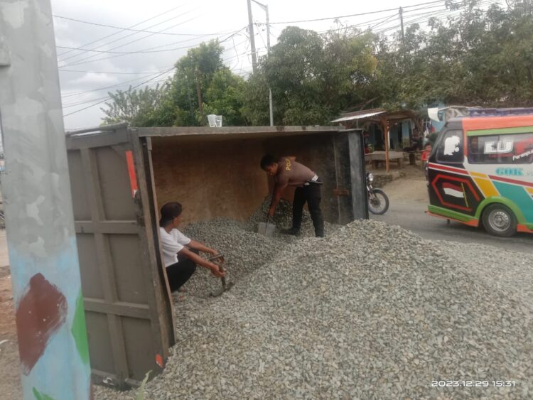 Personil Unit Gakkum Sat Lantas Polres Pematang Siantar, Brigadir Yogi Tobing dengan cepat membantu evakuasi material truk yang terbalik.