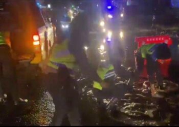 Personel Polres Tanah Karo melakukan penutupan jalan yang berlubang di Jalan Jamin Ginting, Desa Raya, Berastagi, menggunakan bongkahan batu, Jumat (29/12/2023). Akibat adanya lubang yang tergenang banjir di ruas jalan ini, sempat menimbulkan kemacetan di jalur lintas Berastagi-Kabanjahe. (HO)