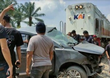 Warga saat melakukan evakuasi Lakalantas mini bus jenis Inova Reborn Vs Kereta Api, di perlintasan tanpa palang pintu, di Jalan Abdul Hamid, Kecamatan Padang Hilir, Kota Tebingtinggi, Minggu (14/1/2024).