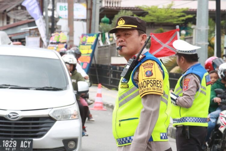 Kapolres Simalungun, AKBP Ronald F.C Sipayung, S.H., S.I.K., M.H, mengatur arus lalulintas, di Pos Pelayanan Pantai Bebas Parapat.