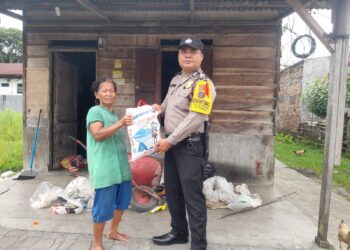 Bripka Johannes C. Siregar, SH, membagikan bantuan sosial (Bansos) dari Kapolres Pematangsiantar, AKBP Yogen Heroes Baruno SH, SIK, kepada warga kurang mampu, Selasa (16/1/2024) siang, pukul 14.00 WIB.