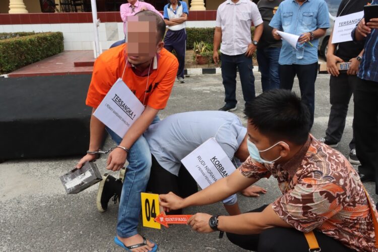 Rekonstruksi  kasus pembunuhan secara bersama - sama, Jumat (2/2/2024), pada pukul 11.00 WIB, di lapangan apel Polres Pematangsiantar.