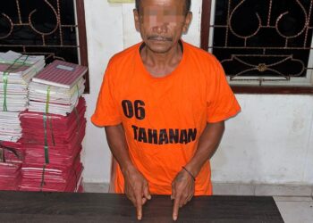 Foto tersangka memperlihatkan barang bukti.