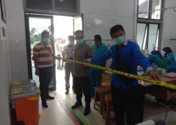 Petugas kepolisian saat melakukan olah TKP.