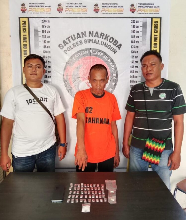 Foto tersangka saat diapit petugas.