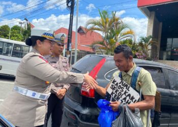 Kasat Lantas Polres Pematangsiantar, AKP Gabriellah A. Gultom SIK, MH, bersama personel, membagikan nasi bungkus kepada warga yang membutuhkan.