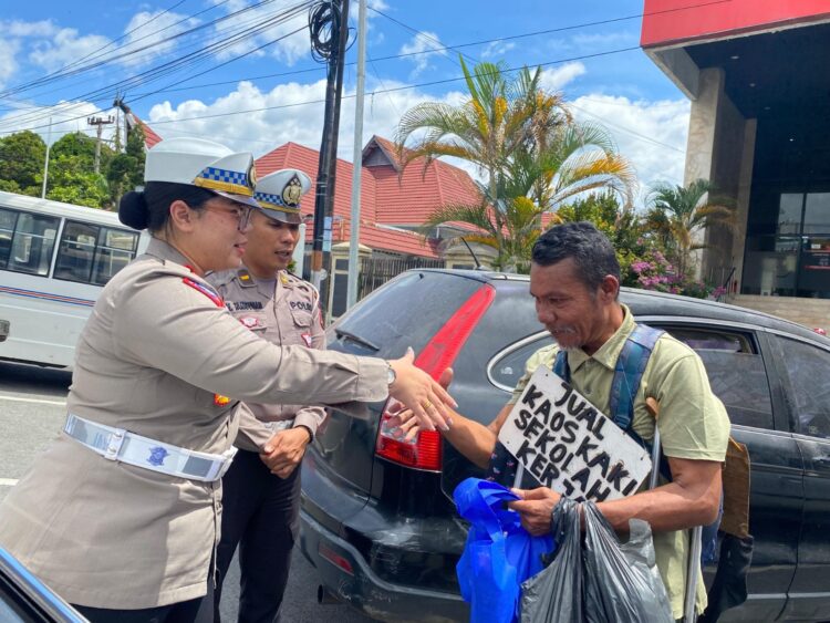 Kasat Lantas Polres Pematangsiantar, AKP Gabriellah A. Gultom SIK, MH, bersama personel, membagikan nasi bungkus kepada warga yang membutuhkan.