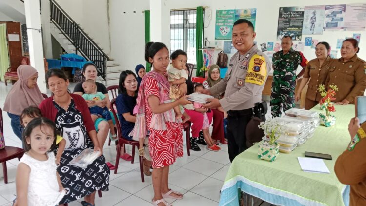 Bhabinkamtibmas Kelurahan Simalungun, Bripkan P. Butarbutar hadiri pemberian makanan tambahan kepada masyarakat.