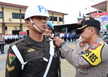 Kapolres Pematangsiantar, AKBP Yogen Heroes Baruno, SH, SIK,memasang pita tanda Ops Hatra Toba Tahun 2024 kepada perwakilan personil peserta Ops Hatra Toba 2024.