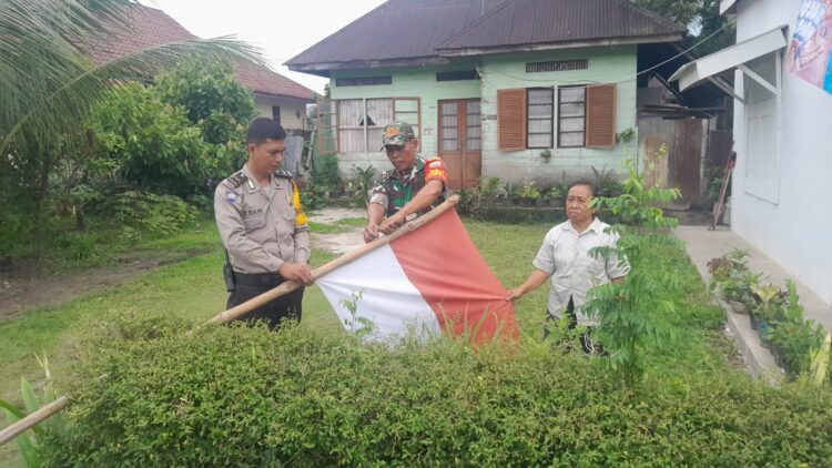 Bhabinkamtibmas Kelurahan Toba, Aipda Eko Silalahi, SH, bersama Babinsa, Serka J. Situmorang, kompak memasangkan bendera merah putih, di depan rumah warga binaannya.