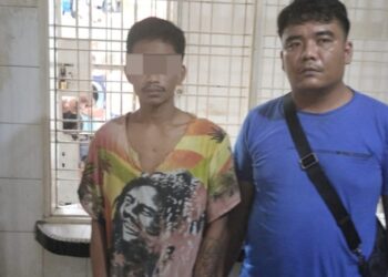 Foto pelaku saat diapit petugas kepolisian.