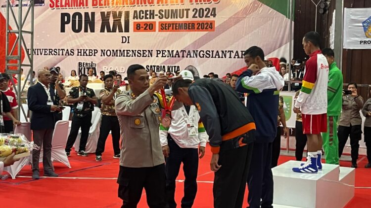 Kapolres Siantar, AKBP Yogen Heroes Baruno, SH, SIK, hadir langsung pada babak final tinju PON XXI Aceh – Sumut dan menyerahkan medali kepada atlit kategori putra yang juara di salah satu kelas.