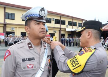 Kapolres Pematangsiantar, AKBP Yogen Heroes Baruno SH, SIK, sematkan Pita Operasi kepada perwakilan personil, pada Senin (14/10/2024) pagi, sekira pukul 08.00 WIB, di Lapangan Apel Polres Pematangsiantar.