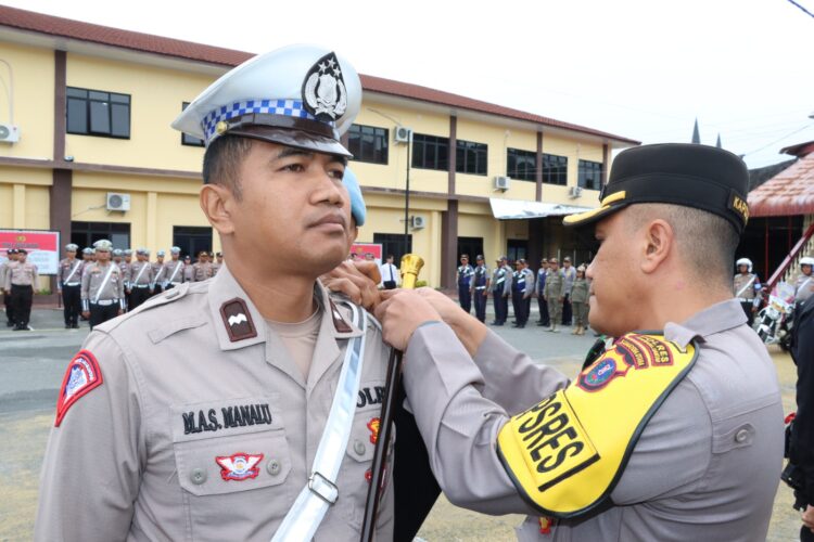 Kapolres Pematangsiantar, AKBP Yogen Heroes Baruno SH, SIK, sematkan Pita Operasi kepada perwakilan personil, pada Senin (14/10/2024) pagi, sekira pukul 08.00 WIB, di Lapangan Apel Polres Pematangsiantar.