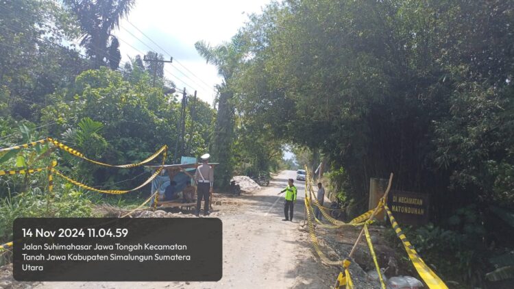 Polsek Tanah Jawa melakukan pengamanan di lokasi perbaikan jalan rusak, di Huta V Suhinagodang, Nagari Tanjung Pasir, Kecamatan Tanah Jawa, Kabupaten Simalungun, pada Kamis (14/11/2024).