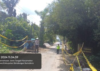 Polsek Tanah Jawa melakukan pengamanan di lokasi perbaikan jalan rusak, di Huta V Suhinagodang, Nagari Tanjung Pasir, Kecamatan Tanah Jawa, Kabupaten Simalungun, pada Kamis (14/11/2024).