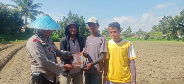 Bhabinkamtibmas Polsek Siantar Marihat, Aipda Abdul Malik menyambangi warga Kelurahan Parhorasan dalam mendorong ketahanan pangan dengan menanam benih jangung, di lahan kosong, Kamis (05/12/2024).