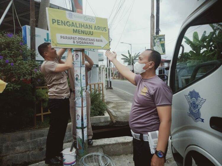 Sat Lantas Polres Pematangsiantar memasang spanduk himbauan, petunjuk arah jalan alternatif dan petunjuk Pos Pengamanan (Pam) dan Pelayanan (Yan) Operasi Lilin Toba Tahun 2024, Sabtu (21/12/2024) siang lalu, pukul 13.00 WIB.