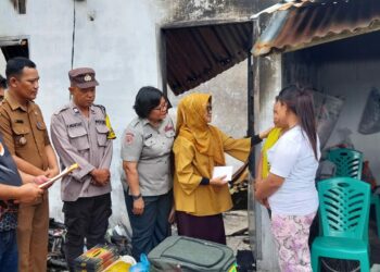 Bhabinkamtibmas Kelurahan Nagahuta Timur, AIPTU F. Munthe, mendampingi Wali Kota Pematangsiantar, dr Susanti Dewayani SpA, saat memberikan bantuan kepada warga yang rumahnya terbakar, pada Selasa (7/1/2025) siang, sekitar pukul 14.20 WIB.