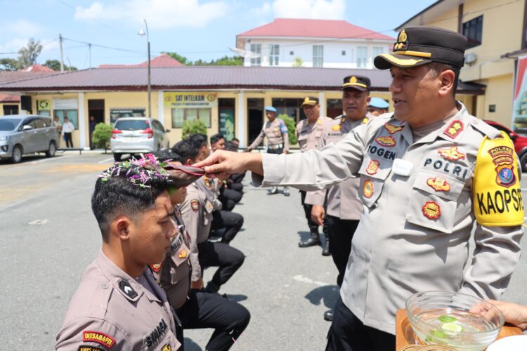 Kapolres Pematangsiantar, AKBP Yogen Heroes Baruno SH, SIK, menyambut 10 personil Bintara Remaja dengan tradisi penyiraman air kembang, pada Senin (3/2/2025) siang.