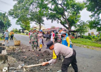 Bhabinkamtibmas Kelurahan Sukamaju, Aipda Adilman Manalu, mengikuti kegiatan gotong royong membersihkan lingkungan.