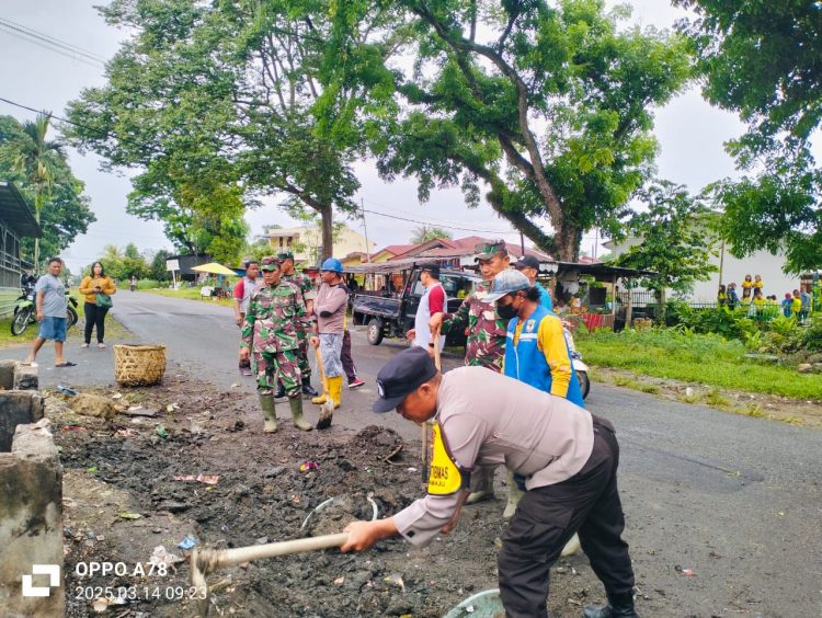 Bhabinkamtibmas Kelurahan Sukamaju, Aipda Adilman Manalu, mengikuti kegiatan gotong royong membersihkan lingkungan.