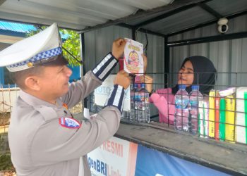 Sat Lantas Polres Simalungun sosialisasi dan penempelan stiker Hotline Mudik Polri 110 kepada masyarakat, di Jalan Asahan Batu 6, Kecamatan Siantar, Kabupaten Simalungun, pada Selasa (18/3/2025).