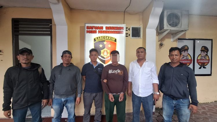 Foto pelaku diapit petugas dengan tangan diborgol.