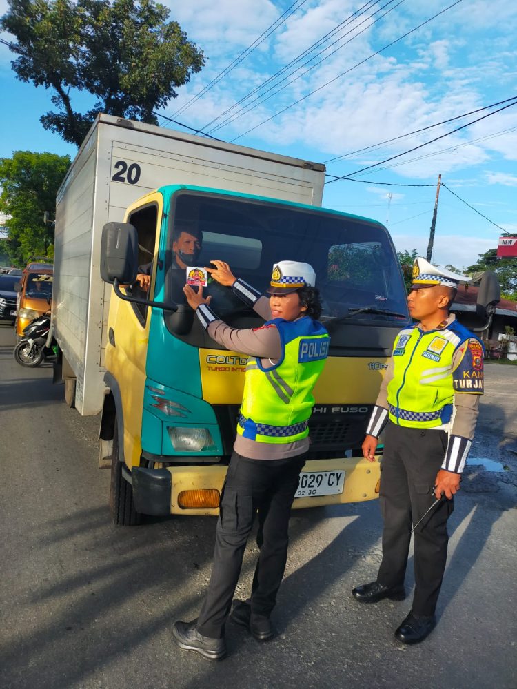 Sat Lantas Polres Pematangsiantar melaksanakan pembagian brosur tertib berlalu lintas dan stiker Layanan Polisi 110, di Jalan Medan, tepatnya depan Pabrik Tapioka, Kecamatan Siantar Martoba, Kota Pematangsiantar, pada Sabtu (14/6/2025) pagi.