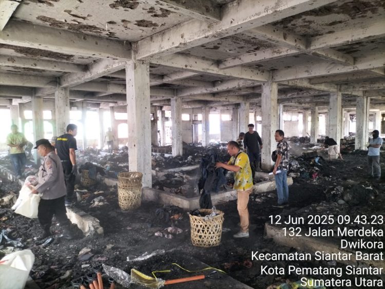 Kasub Sektor Pasar Horas, AIPTU Edi Syahputra SH, melakukan pembersihan sisa barang dagangan yang terbakar di Gedung 4 Lantai 2 Pasar Horas, Jalan Merdeka Pematangsiantar, pada Kamis (12/6/2025) pagi.