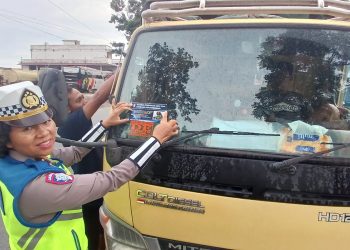 Kanit Kamsel, IPDA Serly Tarigan SH, melaksanakan pembagian brosur dan stiker larangan overload dan overdimensi, di Jalan Parapat, Kecamatan Siantar Marimbun, Kota Pematangsiantar, pada Kamis (19/6/2025) pagi.