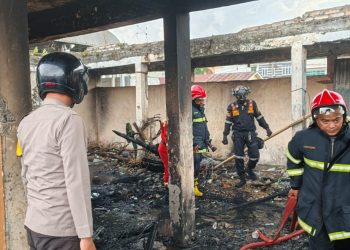 Personil Polsek Siantar Utara melakukan pengecekan terjadinya kebakaran ban dan springbed atau tempat tidur, di bangunan eks Gudang Agribisnis Parluasan, Jl. Sisingamangaraja, pada Selasa (22/7/2025) sore.