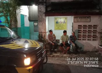 Bhabinkamtibmas, Bripka Agus Rumahorbo dan Bripka Surya Darma, melaksanakan kegiatan Saling (Sapa Siskamling) di Pos Kamling Jalan DR. Wahidin, Kelurahan Dwikora, Kecamatan Siantar Barat, Kota Pematangsiantar, pada Sabtu malam (26/7/2025).