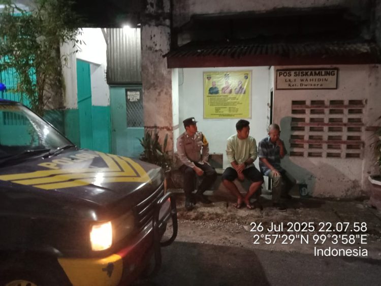 Bhabinkamtibmas, Bripka Agus Rumahorbo dan Bripka Surya Darma, melaksanakan kegiatan Saling (Sapa Siskamling) di Pos Kamling Jalan DR. Wahidin, Kelurahan Dwikora, Kecamatan Siantar Barat, Kota Pematangsiantar, pada Sabtu malam (26/7/2025).