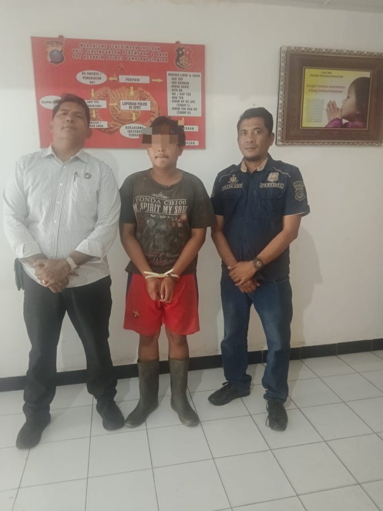 Foto pelaku diapit petugas.