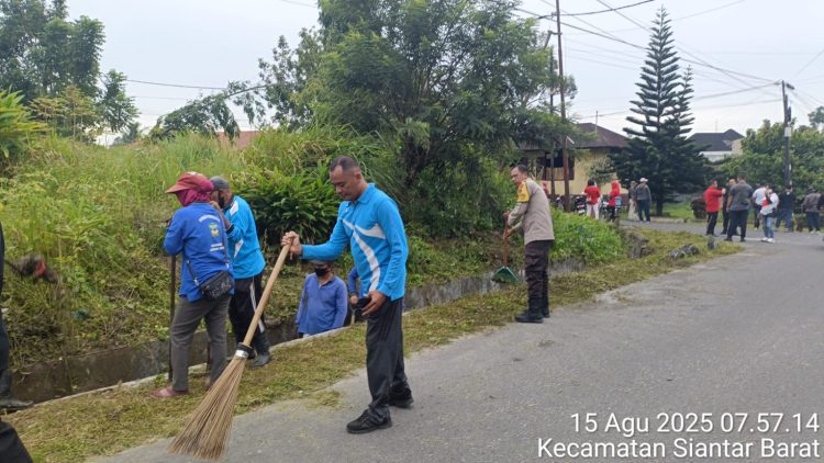 Bhabinkamtibmas Kelurahan Timbang Galung, Aiptu Deddy Syam, mengikuti gotong royong di Jalan Enggang, Simpang Jalan Merpati, pada Jumat (15/8/2025) pagi.