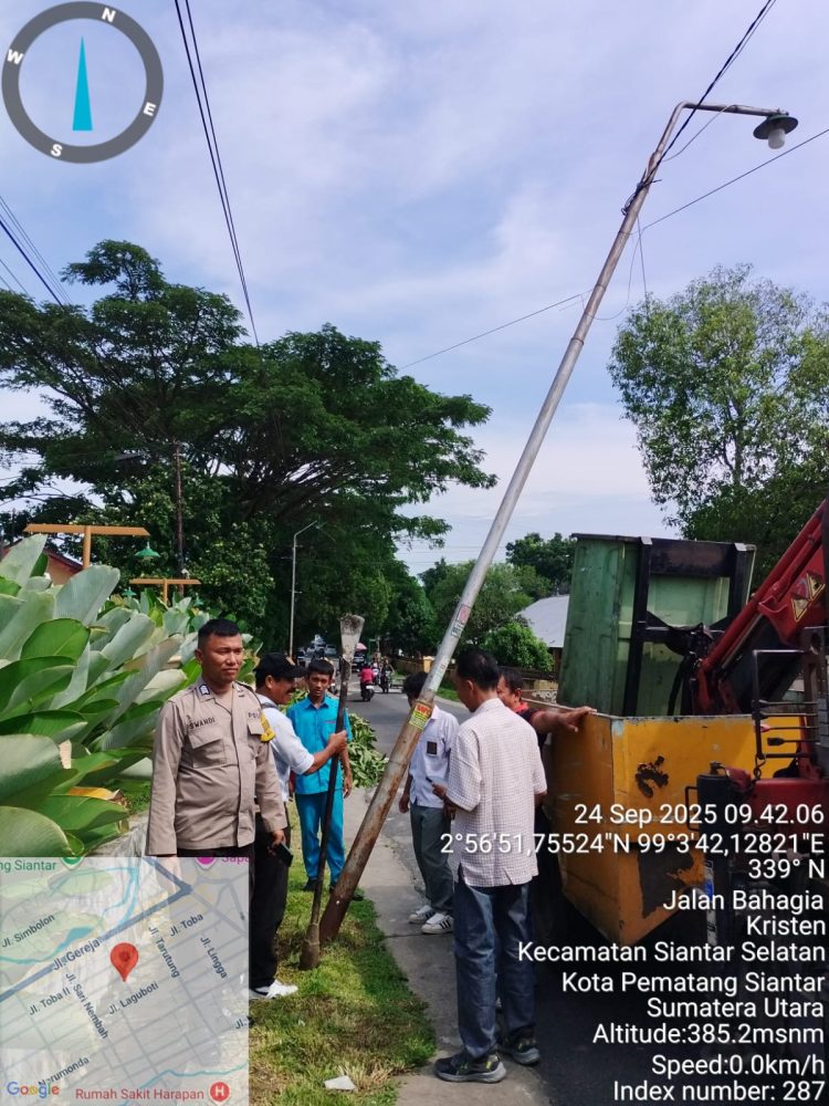 Bhabinkamtibmas Kelurahan Kristen, BRIPKA Swandi, mendampingi instansi terkait dalam perbaikan tiang listrik akibat angin puting beliung, di Jalan Bahagia Pematangsiantar, pada Rabu (24/9/2025) siang.