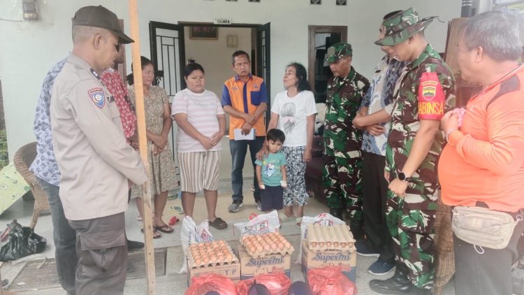 Bhabinkamtibmas Kelurahan Nagahuta Timur, AIPDA F. Munthe melaksanakan pendampingan pembagian bantuan kepada warga terdampak bencana alam angin puting beliung, di Jalan D.I Panjaitan, pada Kamis (25/9/2025) siang.