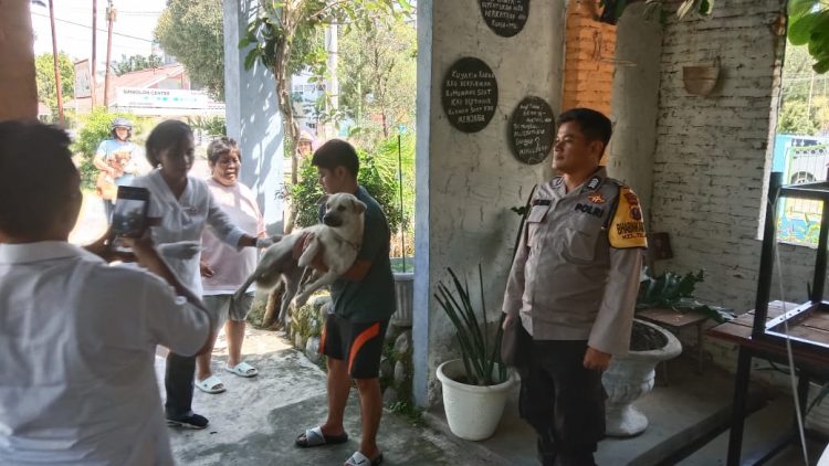 Bhabinkamtibmas Kelurahan Teladan, BRIPKA Irwan Surya Darma, mendampingi petugas kesehatan melakukan vaksinasi rabies hewan peliharaan masyarakat, di Jalan Simbolon, pada Rabu (8/10/2025) pagi.