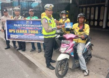 Bhabinkamtibmas Kelurahan Aek Nauli, AIPDA Herry S. Tarigan, ikut pelaksanaan Operasi Zebra Toba Tahun 2025 kepada Ojek Online (Online) di Jalan Gereja, pada Rabu (26/11/2025) pagi.