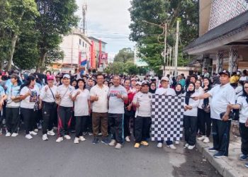 Ketua Panitia Perayaan HUT PGRI Ke-80 dan HGN Tahun 2025, Restar Revolita Tambunan, S.Pd, M.Pd, didampingi panitia lainnya melepas peserta jalan santai.